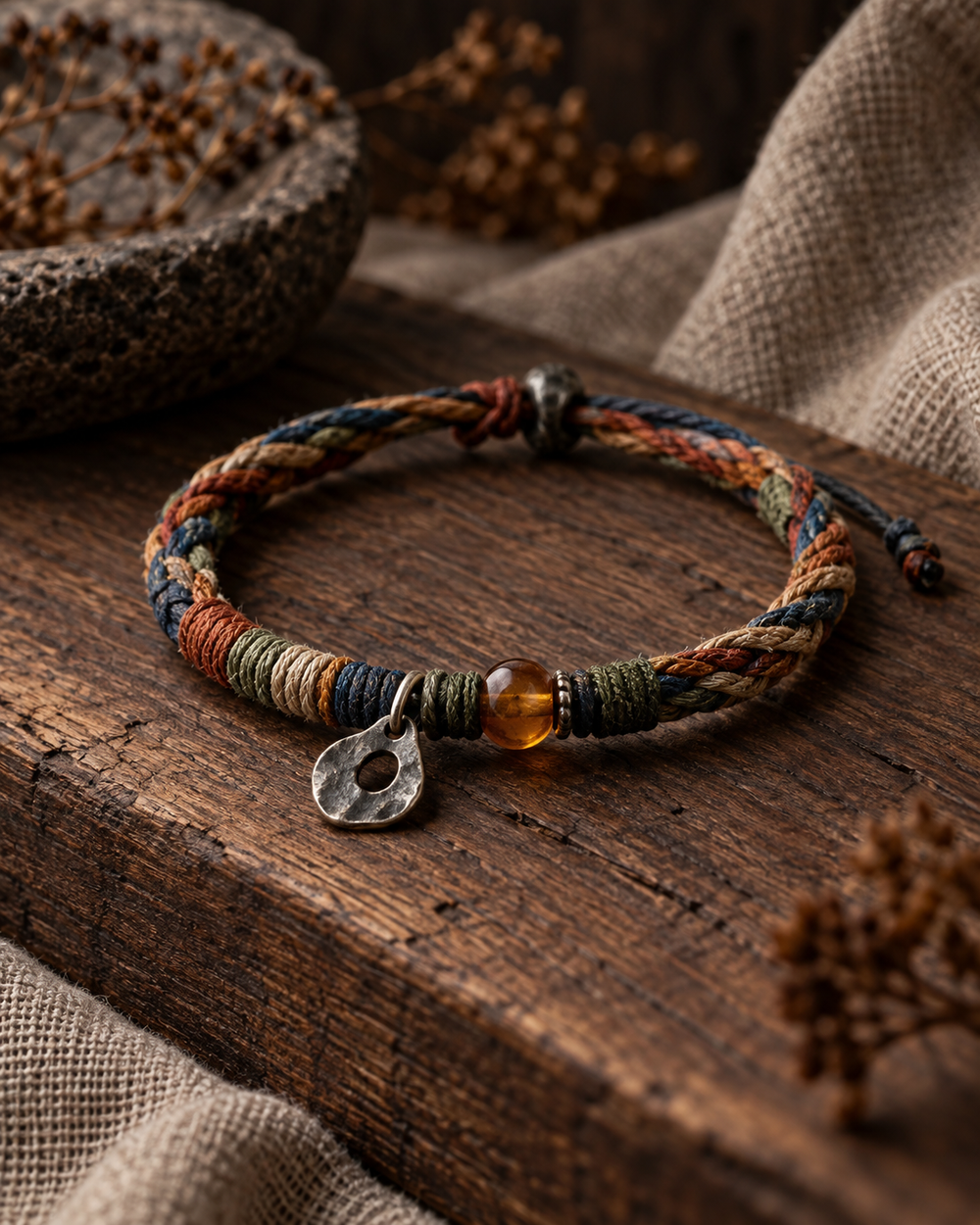 Multicolor handwoven cord bracelet with amber bead and silver charm